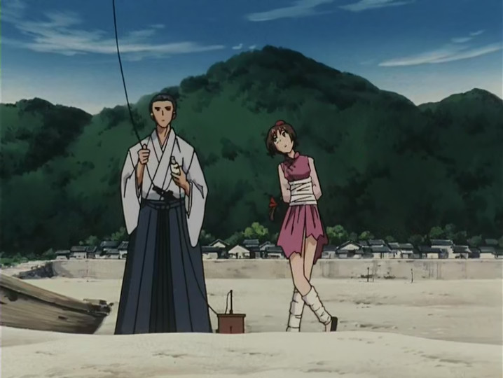 Meow from Tsukikage Ran standing next to a man on the beach.